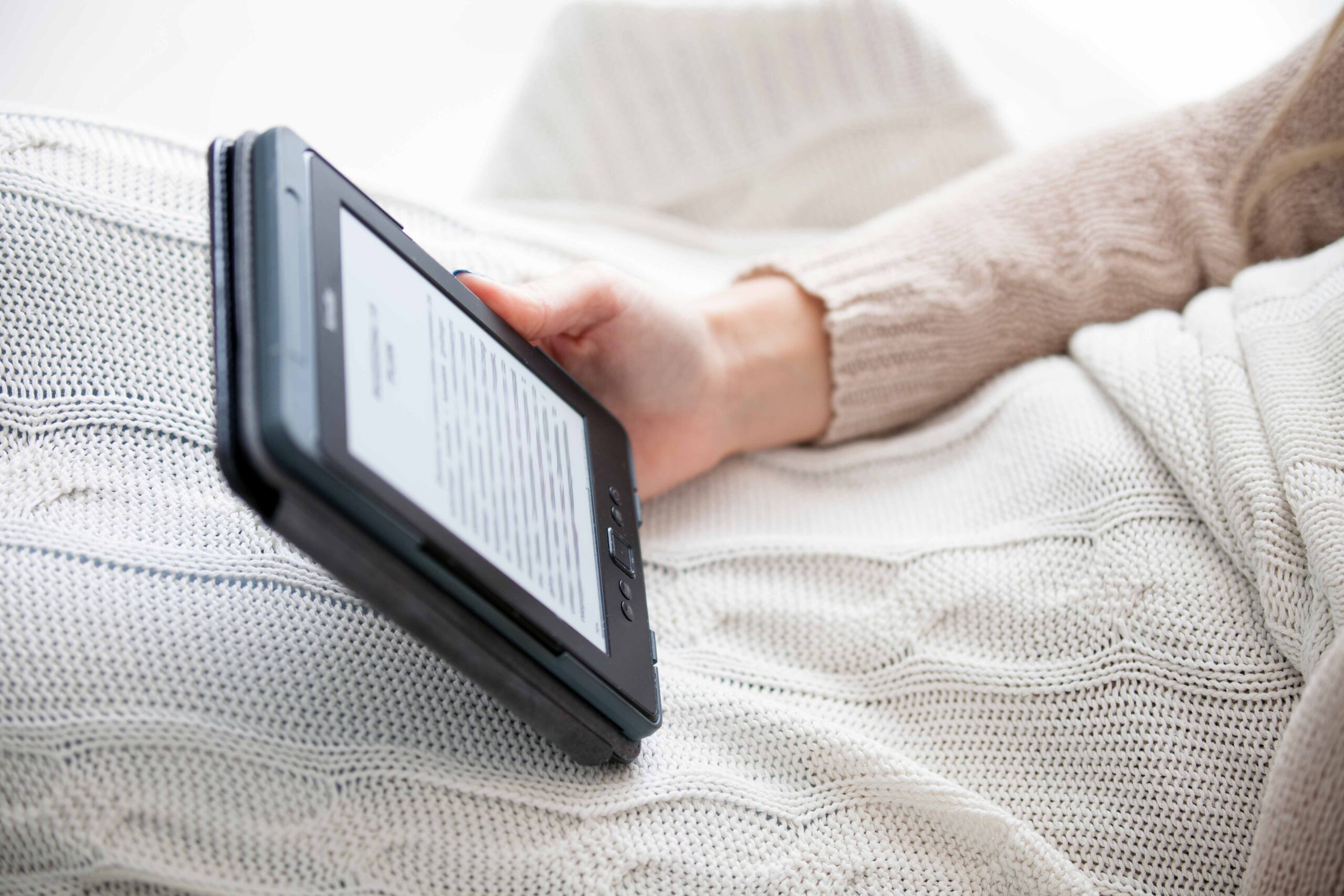 digital-ebook-reader-holding-by-woman-at-cozy-home-2024-10-31-04-21-42-utc